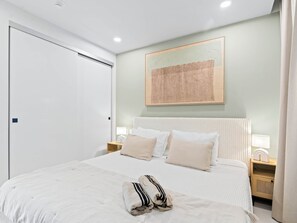 A bedroom with a bed, nightstands, a wall-mounted artwork, and a door. - D402 - Beautiful apartment with garden and view (Cole Bay)