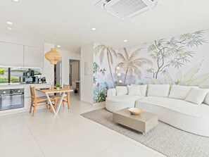 Ein modernes Wohnzimmer mit einer Couch, einem Couchtisch und einem Essbereich.