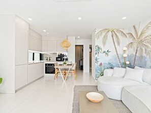 A modern living space with a kitchen, dining area, and a seating area with a wall mural. - D402 - Beautiful apartment with garden and view (Cole Bay)