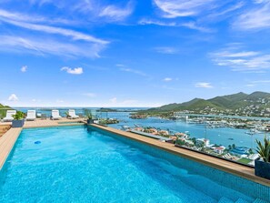 A swimming pool with a view of a marina and mountains. - D402 - Beautiful apartment with garden and view (Cole Bay)