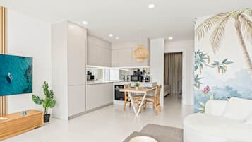 Un salon moderne avec un canapé, une table basse et un téléviseur fixé au mur.