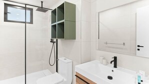 A modern bathroom with a glass shower enclosure, a toilet, a vanity with a sink, and a mirror. - D432 Very beautiful apartment with a balcony (Cole Bay)