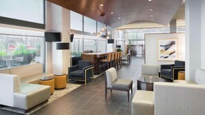 A spacious lounge area with comfortable seating, a dining area, and large windows offering views of the outdoors. - Near Independence Hall + Free Breakfast. Bar. Gym. (Philadelphia)