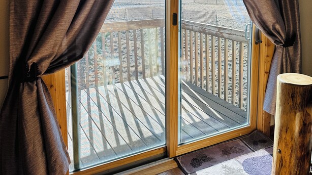 A room with a sliding glass door leading to a deck. - Peaceful Rustic Mountain Getaway-Aspen Peaks Retreat (Hartsel)