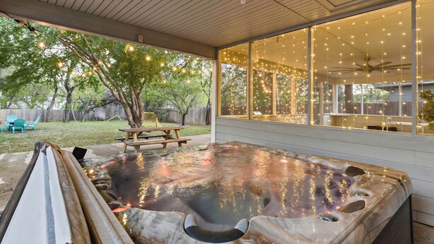 A hot tub with a wooden deck, a ceiling fan, and string lights. - Cozy 5BD/fun house (Austin)