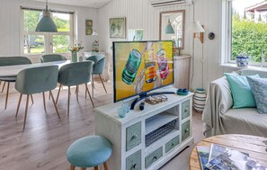 A modern living room with a television, dining area, and a view of greenery outside. - Pet friendly home in Slagelse with WiFi (Slagelse)