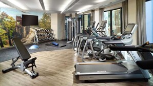 Ein modernes Fitnessstudio im Hotel mit Laufbändern, Crosstrainern und Gewichten.