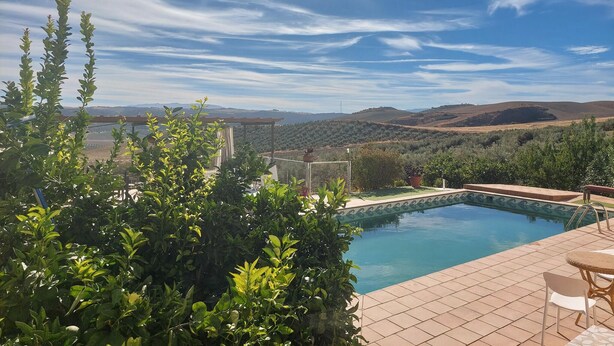 Une piscine offrant une vue sur les collines et un ciel dégagé.