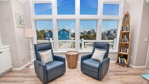 A room with two leather armchairs, a wooden coffee table, and a bookshelf. - Semi-Oceanfront, Ocean Views, Priv. Pool, Hot Tub-WL922, Beauty and the Beach (Corolla)