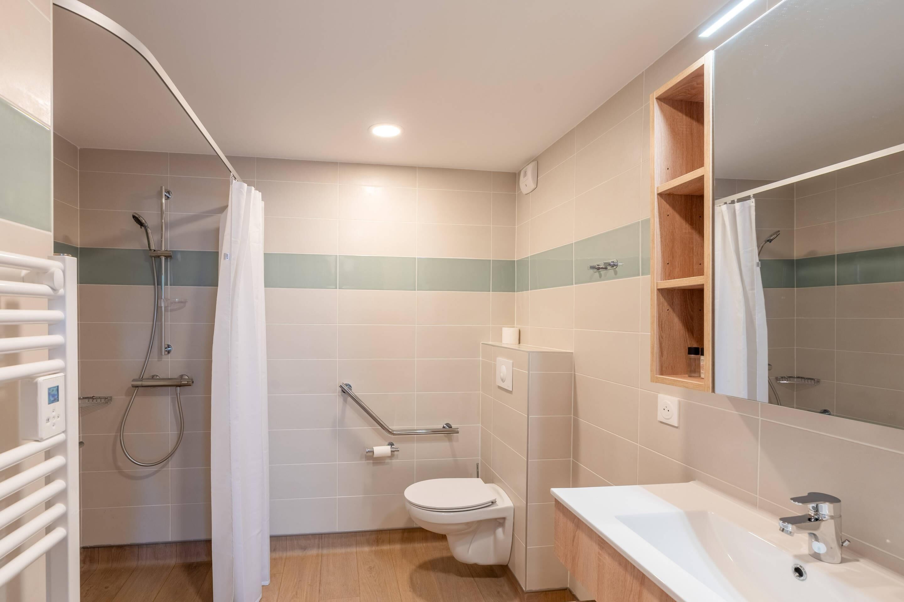 A modern bathroom with a shower, toilet, and sink.