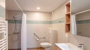 A modern bathroom with a shower, toilet, and sink.