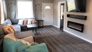 A modern living room with a sofa, a coffee table, and a fireplace.