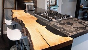 A kitchen with a large wooden island, a gas stove, and a toaster.