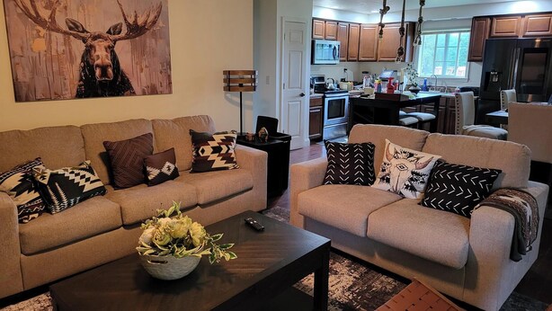A modern living room with two sofas, a coffee table, and a painting of a moose. - Ride from your door Atv Trails & Swim,Fish in Tug Hill Plenty of Trailer Parking (Redfield)