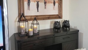 A dark wooden desk with two lit candles in glass lanterns, a framed artwork of deer, and two black pig figurines. - Ride from your door Atv Trails & Swim,Fish in Tug Hill Plenty of Trailer Parking (Redfield)