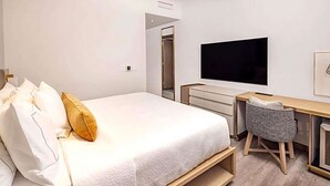 A bedroom with a bed, a desk, a chair, a TV, and a wardrobe. - High End 1-Bedroom Studio Premier Plus in Midtown Manhattan with many amenities (New York)