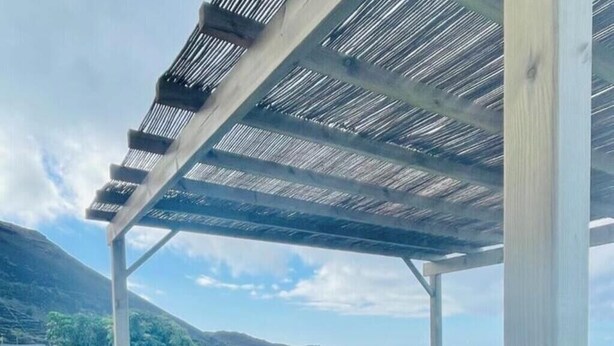 A covered outdoor area with a pool, two lounge chairs, and a view of the ocean and hills. - Beautiful and quiet house Los Quemados, Fuencaliente de La Palma. (fuencaliente de la palma)