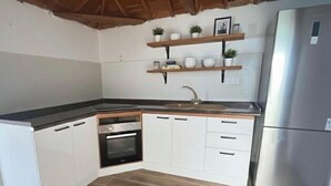 A kitchen with white cabinets, a stainless steel refrigerator, and wooden flooring. - Beautiful and quiet house Los Quemados, Fuencaliente de La Palma. (fuencaliente de la palma)