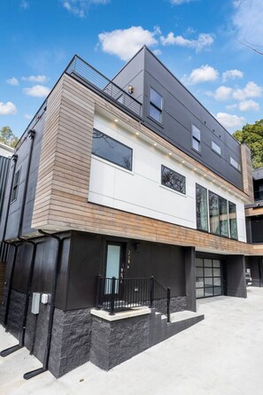 A modern multi-story residential building with a flat roof, large windows, and a balcony. - Glamour on the Rocks - Nashville's Most Instagrammable Luxury Stay - Sleeps 12 (Nashville)