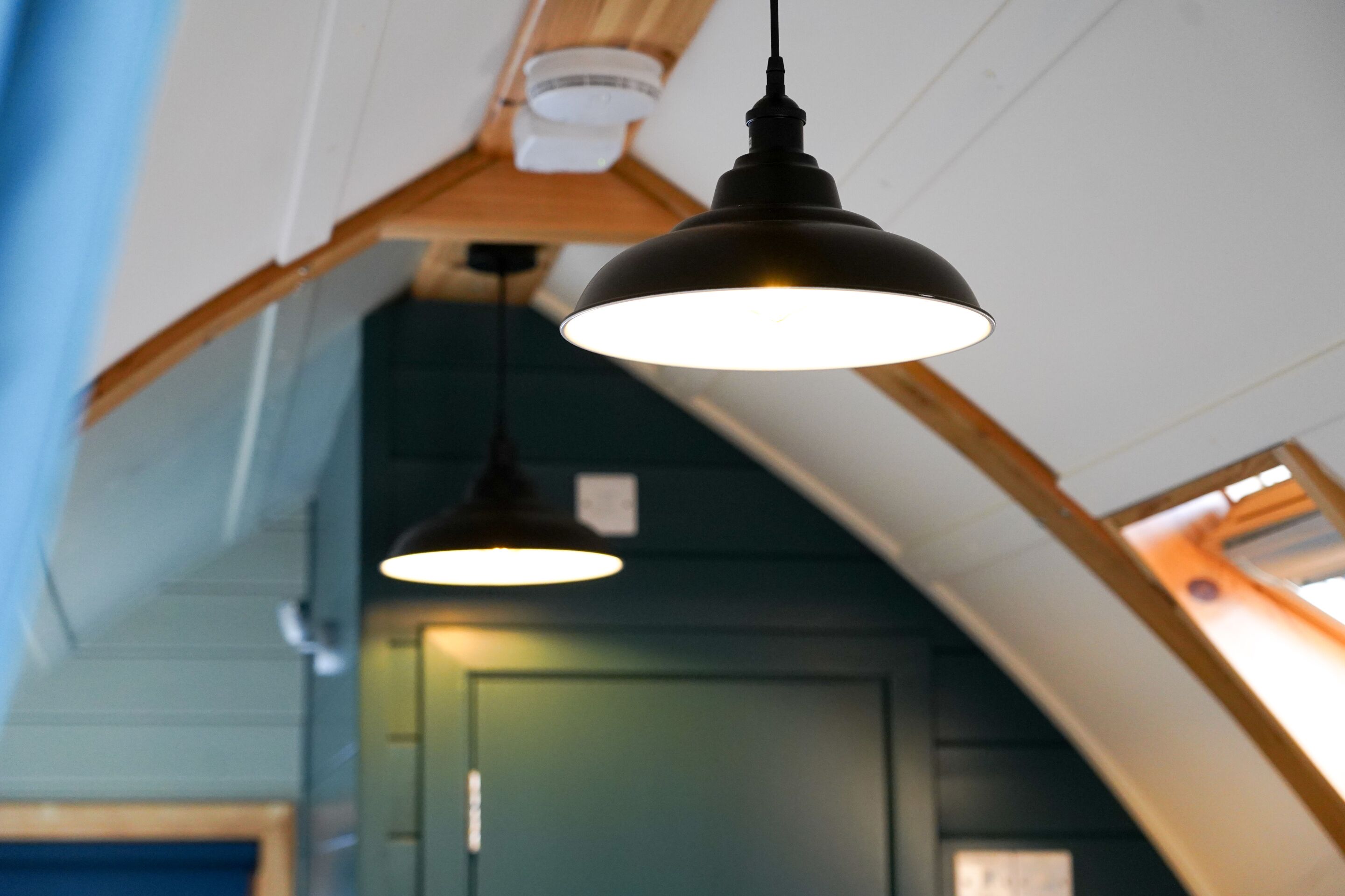A ceiling with two pendant lights and a sloped roof structure.