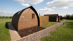 A wooden cabin-style building with a sloped roof and a small window.