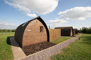 Un bâtiment de style cabane en bois, doté d’un toit en pente et d’une petite fenêtre.