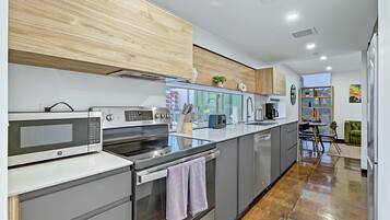 A modern kitchen with a built-in oven, microwave, and stainless steel appliances.