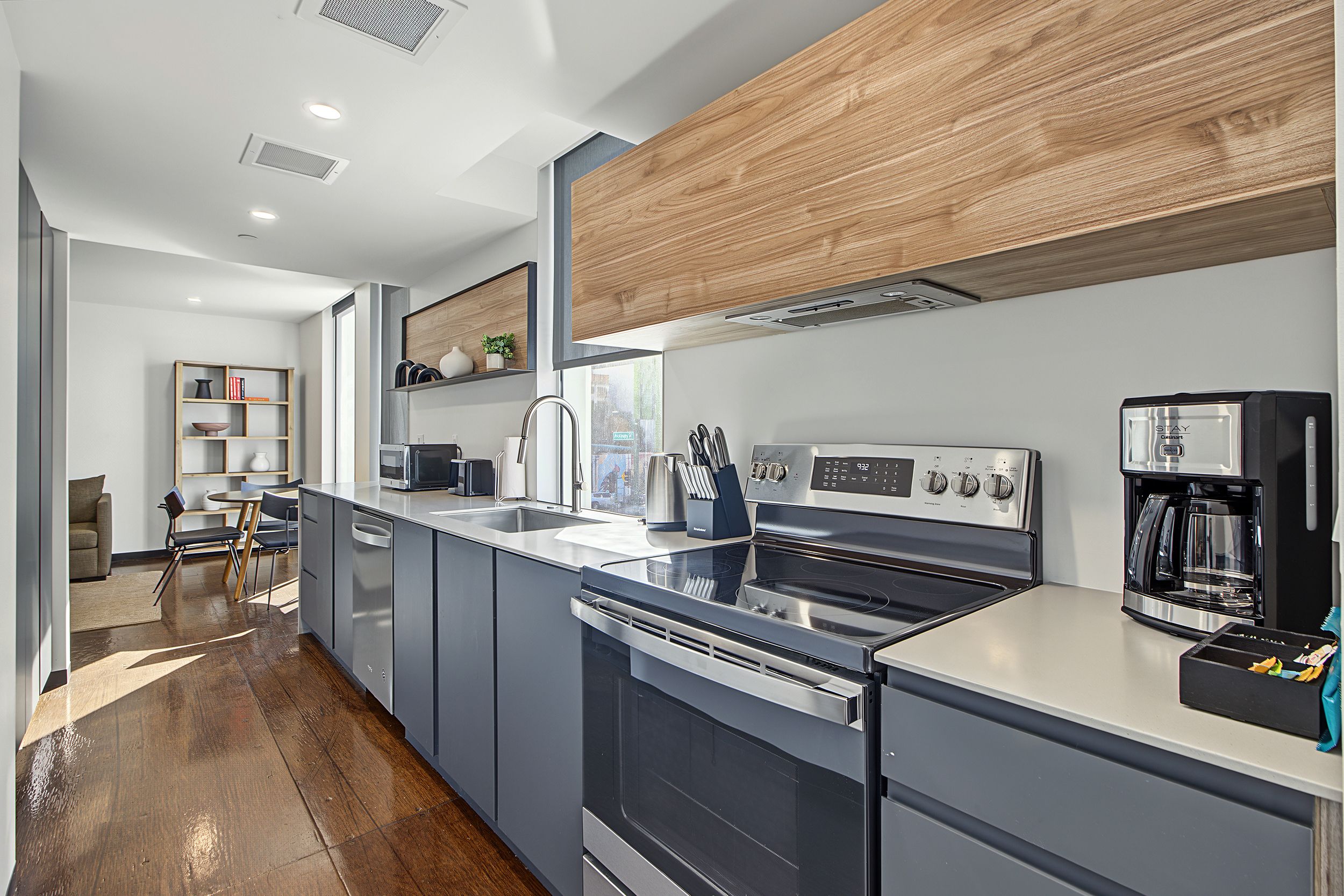 A modern kitchen with a built-in oven, a coffee maker, and a sink.