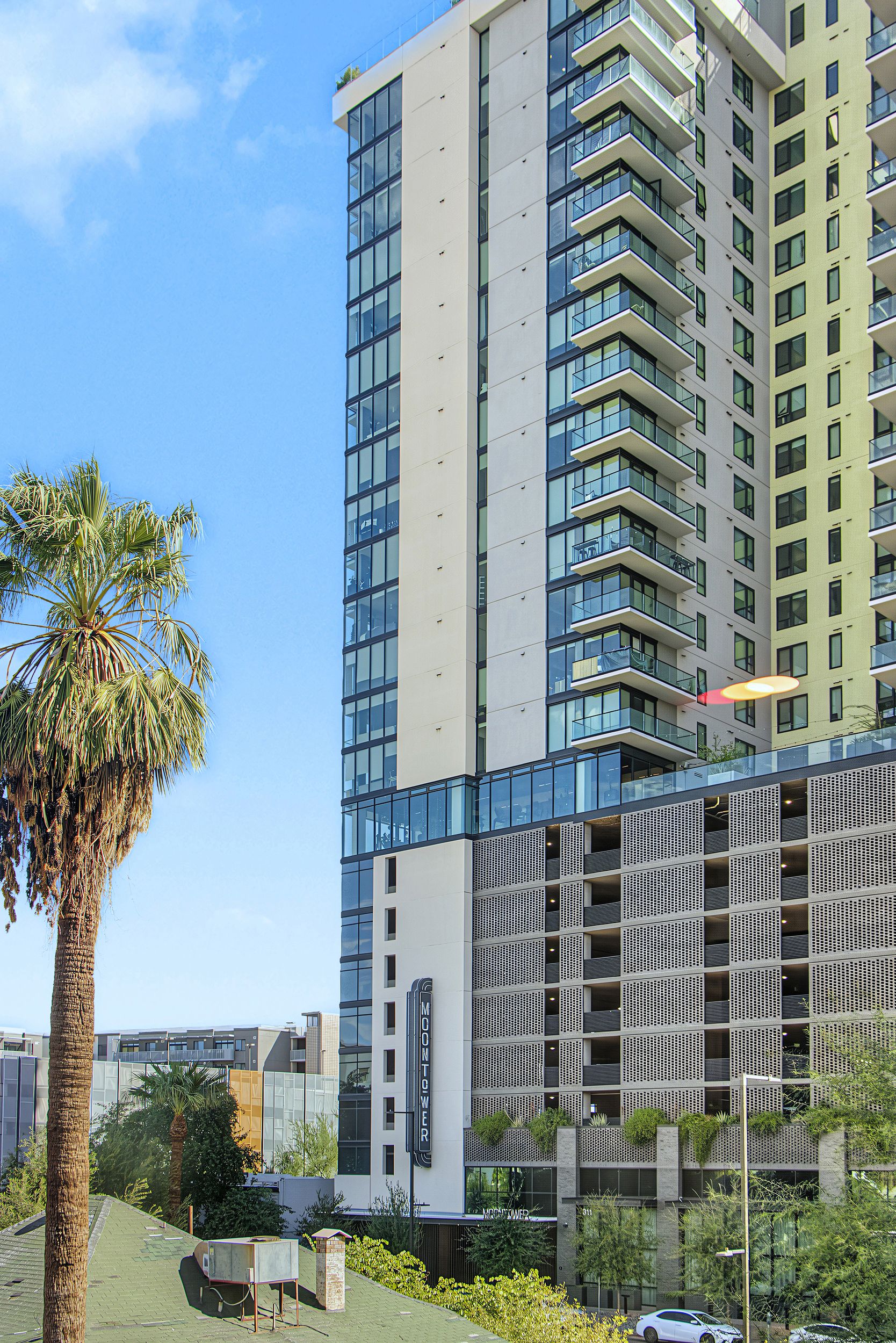 A modern high-rise building with multiple balconies and a glass facade.