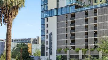 A modern high-rise building with multiple balconies and a glass facade.