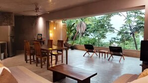 A spacious living area with a dining set, a sofa, and a TV. - The sea in front of your window! (Puerto Vallarta)