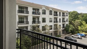 A multi-story residential building with balconies and a parking area. - Cozy 2-bedroom condo in serene Atlanta with AC and fitness room (Atlanta)