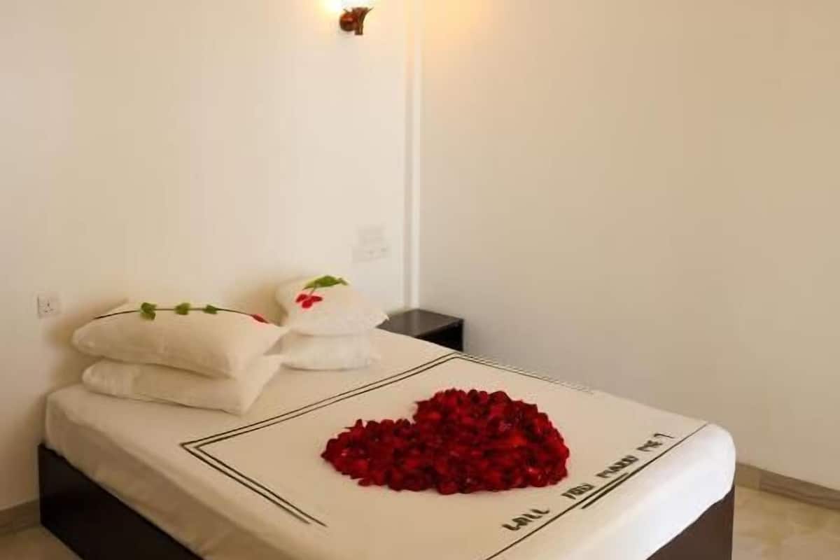 A bedroom with a bed, a ceiling fan, and two wall-mounted lights.