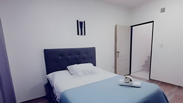Ein Schlafzimmer mit einem Bett, einem Nachttisch und einem Kleiderschrank.