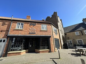A brick building with a sign reading "The Four Cats Drinks and Eats".