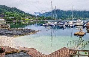 A marina with boats docked, a wooden dock, and a mountainous backdrop. - 3 bedroom awesome home in Strandebarm (Strandebarm)