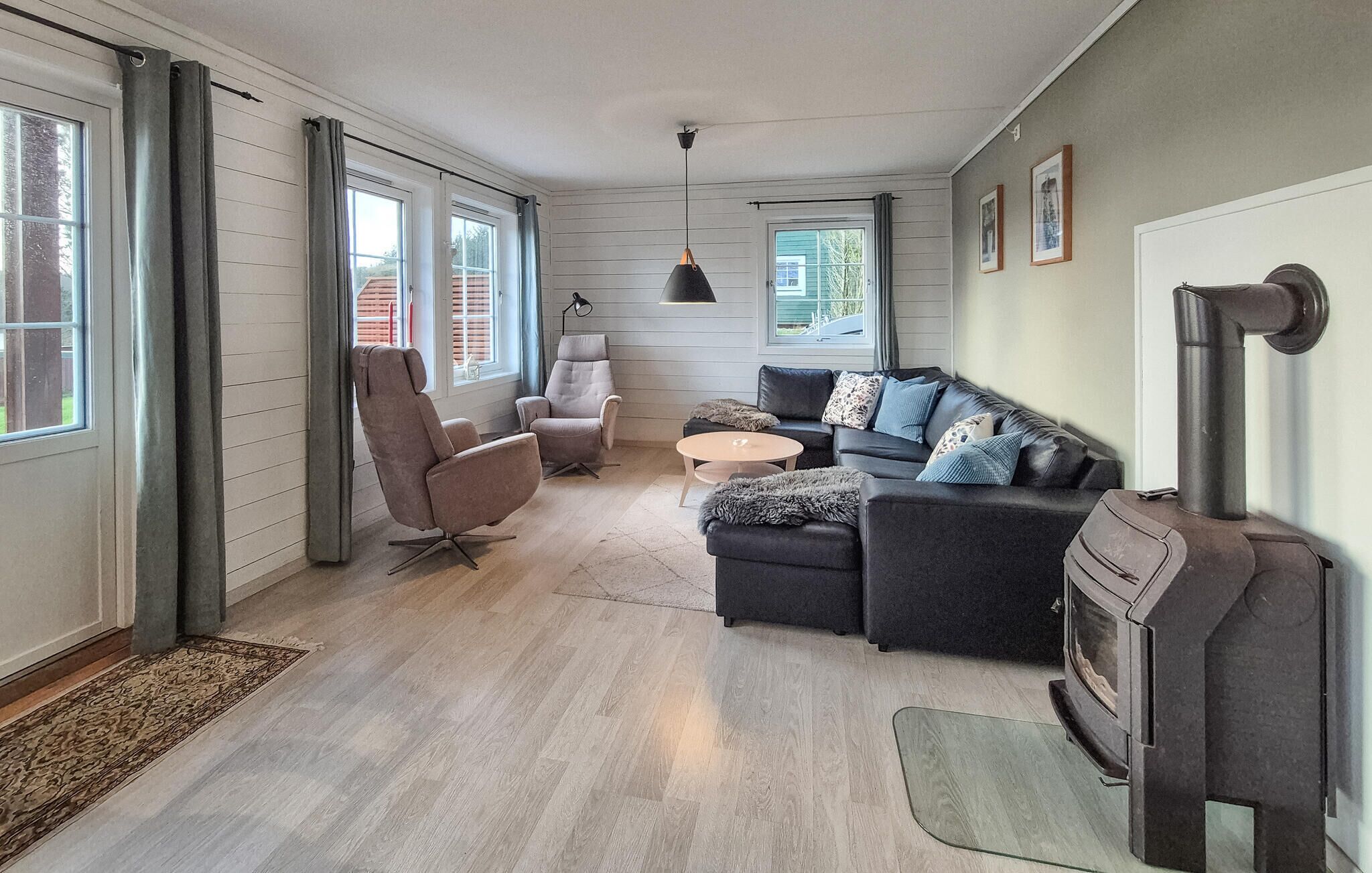 Un salon moderne comprenant un canapé, des fauteuils, une table basse et une cheminée.