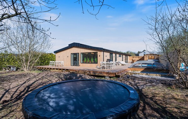 A modern wooden house with a deck, a hot tub, and a trampoline. - Beautiful home in Ejstrupholm (Ejstrupholm)
