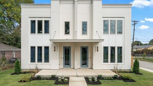 A modern two-story house with a symmetrical facade, large windows, and a central entrance. - The Emerald-Contemporary Art Deco–Style Townhome (Memphis)