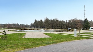 Een park met een vijver, wandelpaden en een picknickplaats.