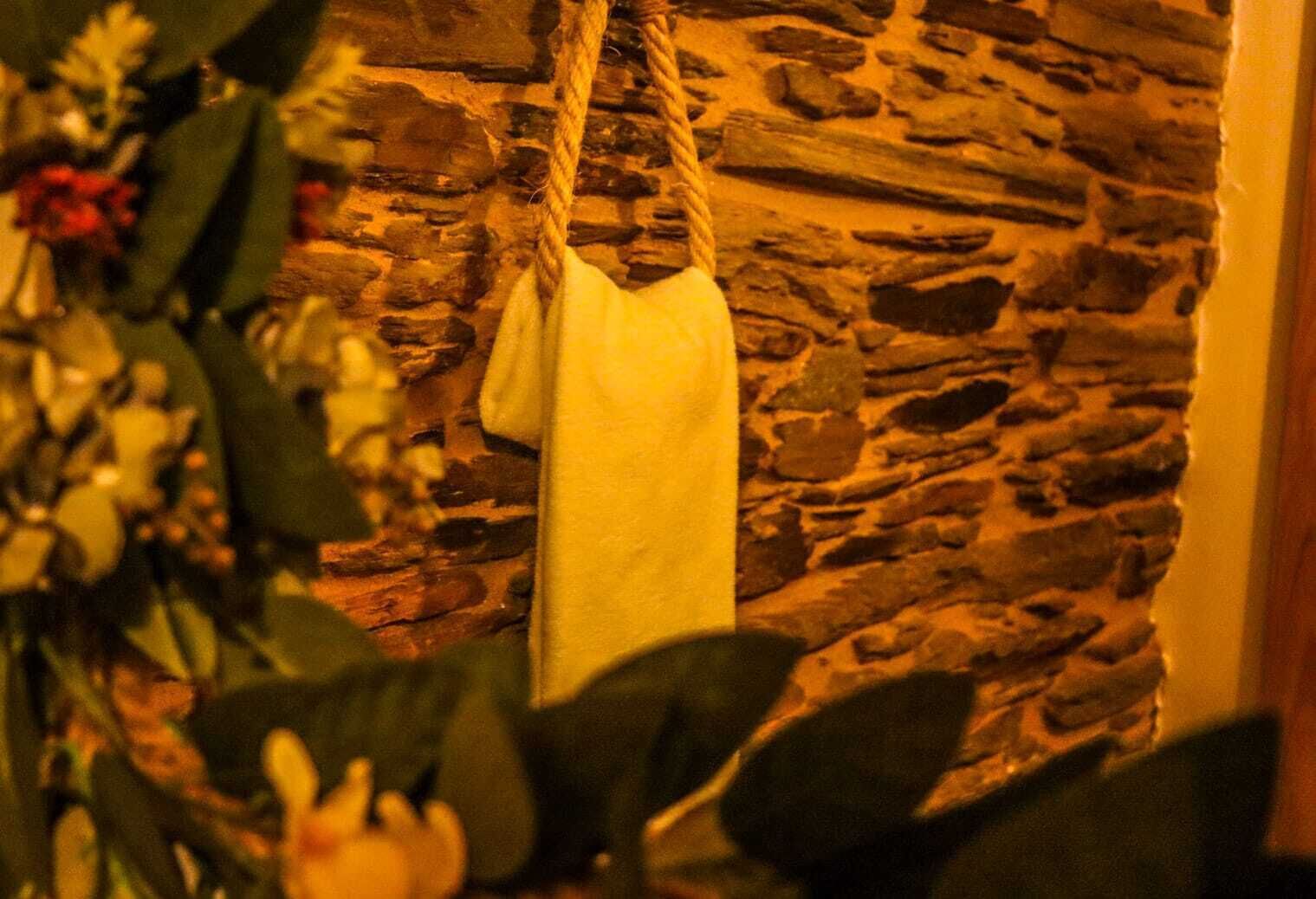 Un mur de pierre avec une serviette blanche suspendue à une corde.