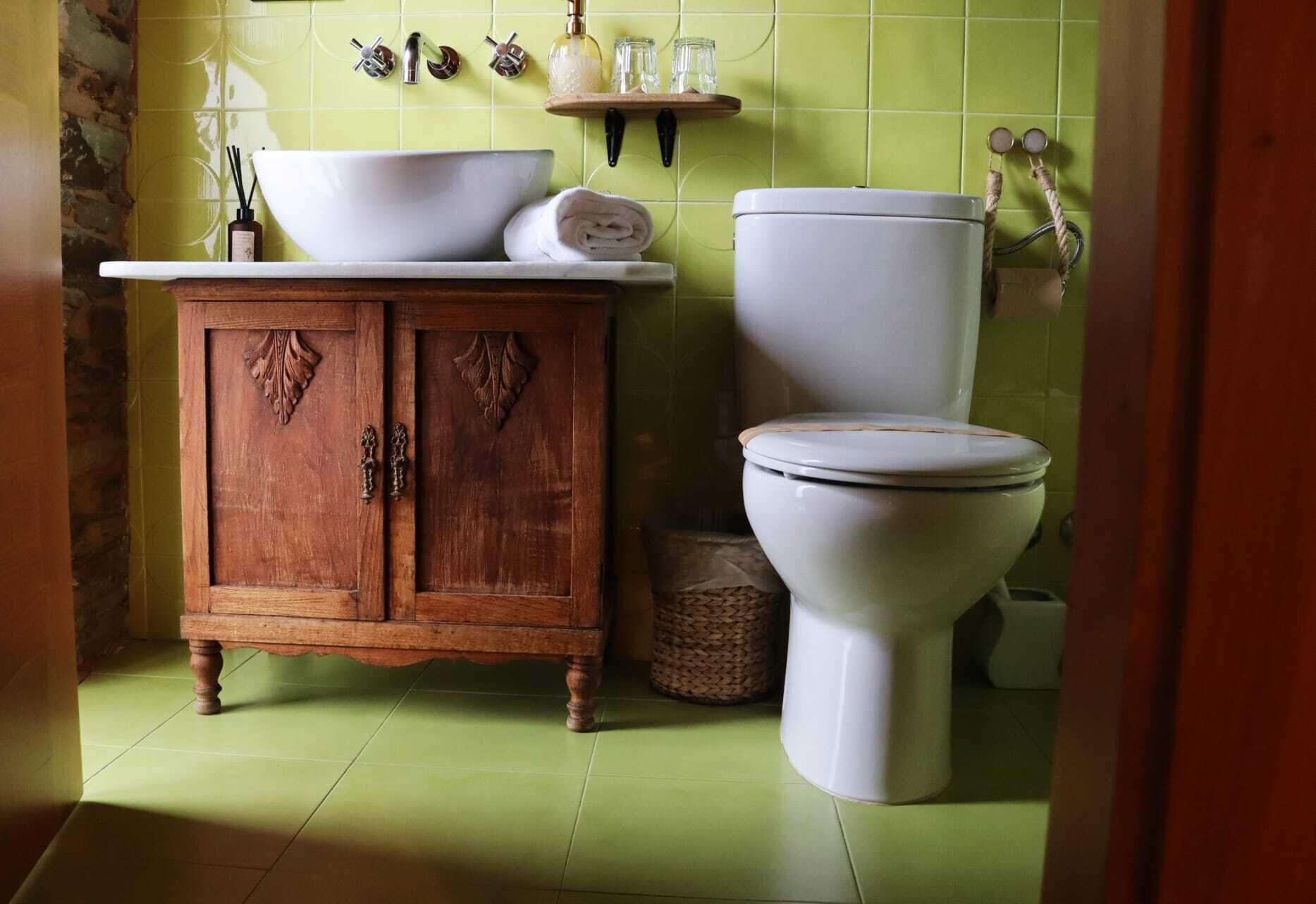 Ein Badezimmer mit einem Holzkabinent, einem weißen Waschbecken und einer Toilette.