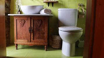 Ein Badezimmer mit einem Holzkabinent, einem weißen Waschbecken und einer Toilette.