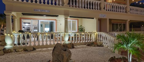 A hotel with a balcony, a sign reading "ROOTS SANTO 12D", and a sign for "LANDS LAKE APARTMENTS".