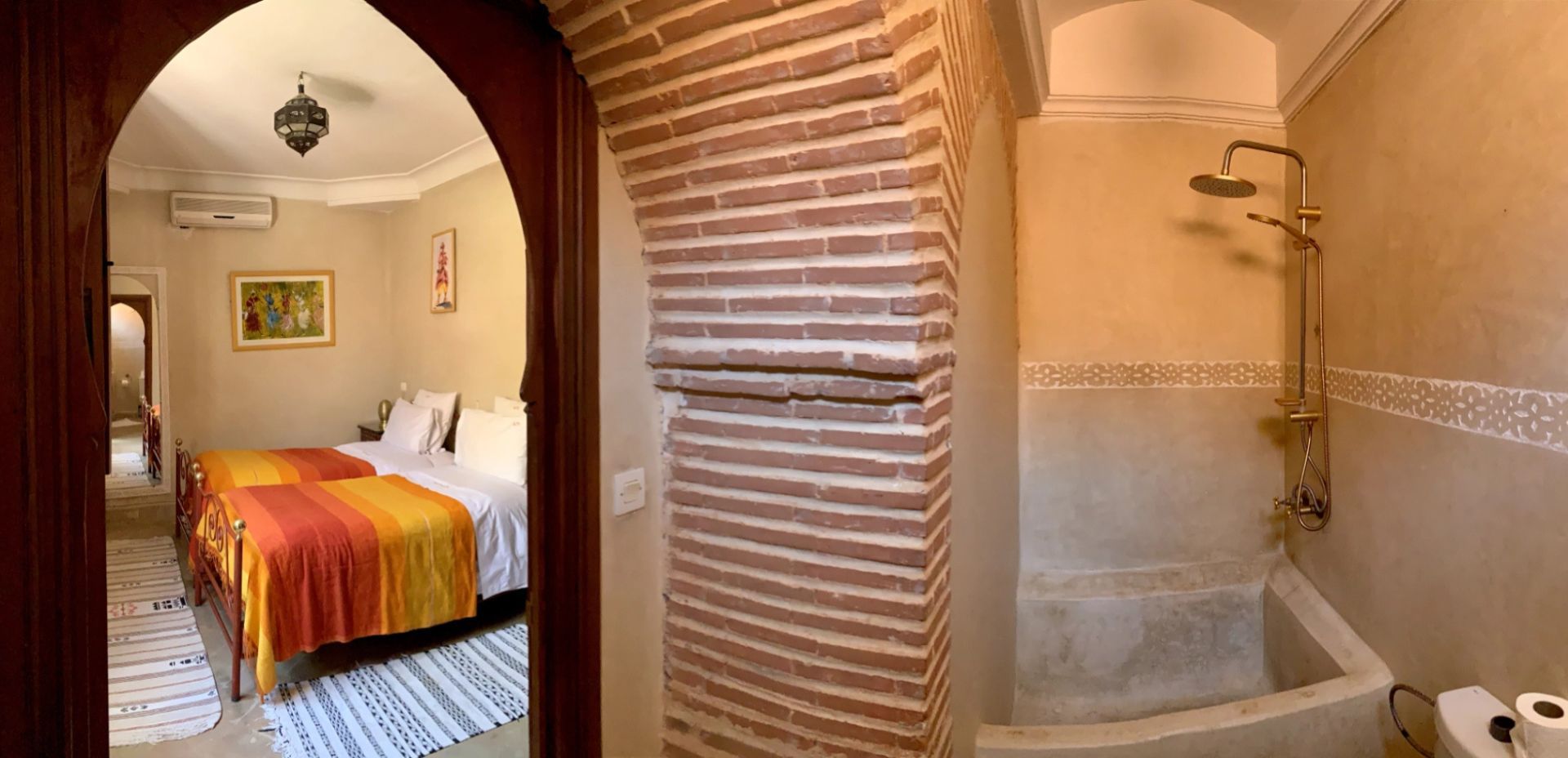 Una habitación de hotel con cama, ducha y un pasillo que conduce a otra habitación.