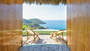 A wooden-framed veranda with two wooden chairs facing a beach view. - Careyes (Costa Careyes)