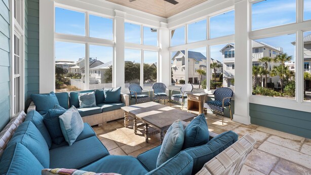 A sunroom with a large window, a ceiling fan, and a seating area with a sofa and chairs. - Blue Palmetto: Grayton Beach Retreat With Pool, Elevator, and 6-Passenger Electric Cart (Santa Rosa Beach)