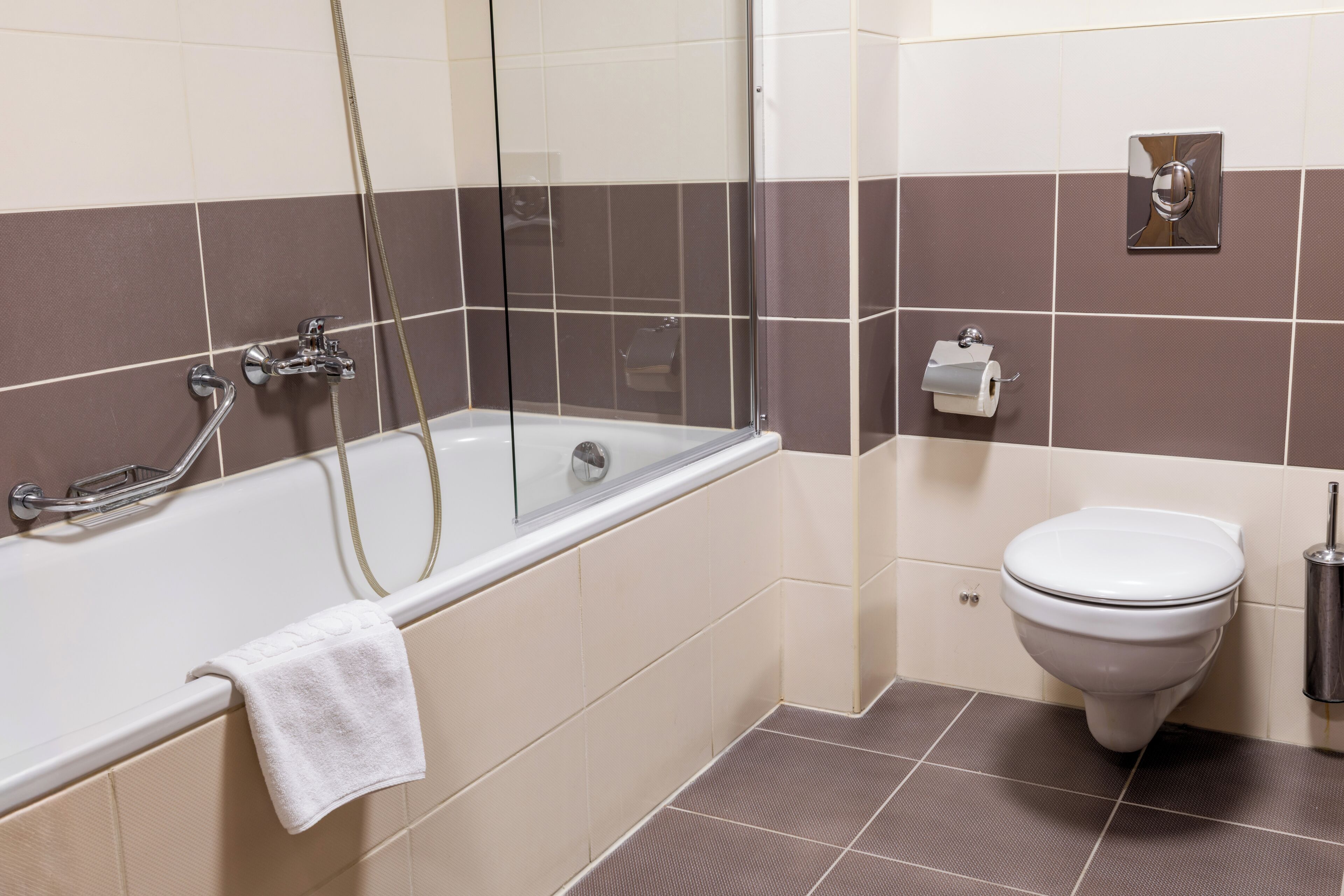 A bathroom with a bathtub, toilet, and a towel rack.