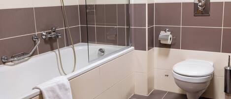 A bathroom with a bathtub, toilet, and a towel rack.
