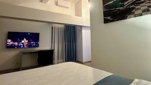 A hotel room with a bed, a flat-screen TV, a desk, and a painting on the wall. - d'or Hotel (Codru)